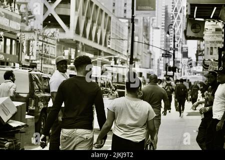 Una foto in scala di grigi di persone che camminano per le strade di New York City. Foto Stock