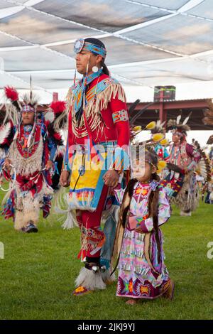 Il ballerino di Pow Wow tiene il bambino mentre balla allo Shoshone Bannock Pow Wow, Fort Hall, Idaho Foto Stock