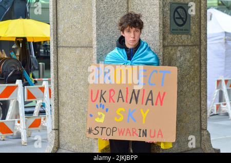 Un giovane dimostratore ha un segnale per chiedere protezione al popolo ucraino di fronte al United Nations Plaza di New York il 26 marzo 2022. Foto Stock