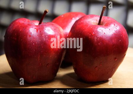 Tre grandi mele rosse della varietà Red Chief. Goccioline d'acqua sulla frutta. Foto Stock