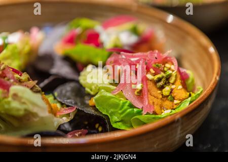 Un primo piano di un'insalata di verdure diverse riempita in un piatto di argilla Foto Stock