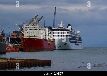 Una nave da carico e una crociera sulle acque del porto di Ushuaia a Tierra del Fuego, Argentina Foto Stock