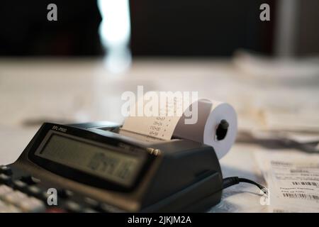 Primo piano di una calcolatrice a stampa con carta stampata con rotolo che completa le tasse annuali Foto Stock