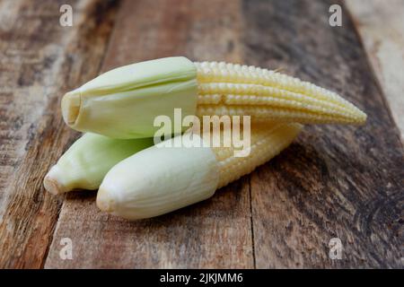 baby corn su sfondo di legno Foto Stock