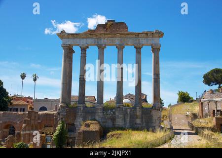 Una vista panoramica sulle rovine del Tempio di Saturno immerso nel verde di Roma Foto Stock