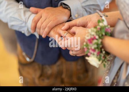 Un primo piano di una giovane coppia che si scambiano anelli durante una cerimonia nuziale Foto Stock