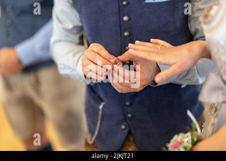 Un primo piano di una giovane coppia che si scambiano anelli durante una cerimonia nuziale Foto Stock