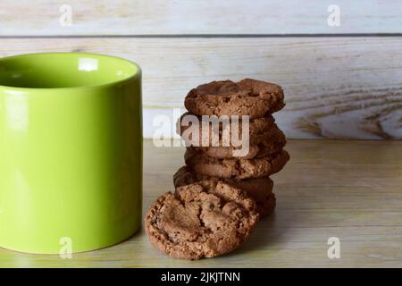 Un primo piano di una pila di biscotti al cioccolato sullo sfondo di legno Foto Stock