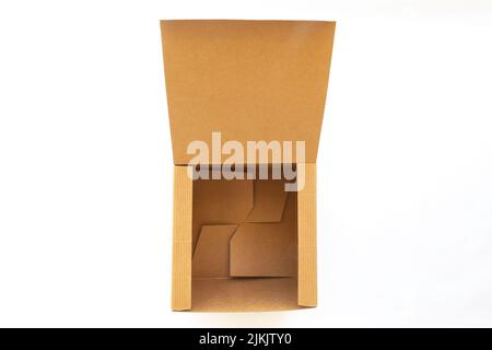Una scatola di cartone ondulato marrone aperto Kraft isolata su sfondo bianco. Foto Stock
