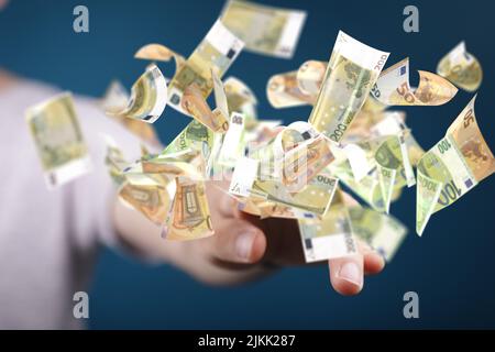 Alcune banconote in euro volano intorno a una mano, su uno sfondo blu Foto Stock