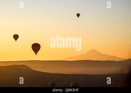 Una bella foto di mongolfiere nel cielo della Cappadocia turca durante il tramonto Foto Stock