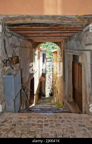 Uno scatto verticale di uno stretto corridoio acciottolato tra vecchi edifici medievali. Foto Stock