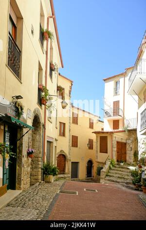 Uno scatto verticale di una strada acciottolata tra vecchi edifici medievali in pietra di giorno. Foto Stock