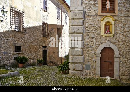 Una strada acciottolata tra vecchi edifici in pietra medievale di giorno. Foto Stock