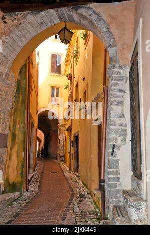 Uno scatto verticale di uno stretto corridoio acciottolato tra vecchi edifici medievali. Foto Stock