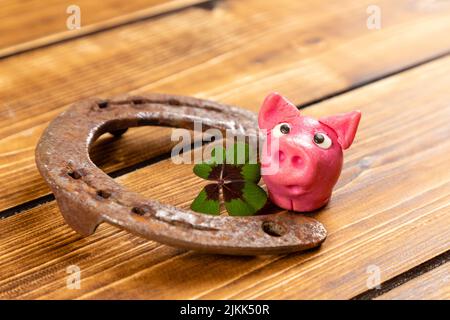 horseshoe con verde shamrock e segno di maialino fortunato per fortuna per la giornata di san patricks su uno sfondo di legno Foto Stock