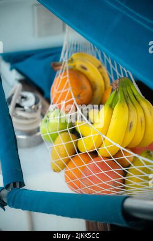 Un primo piano verticale di frutta fresca in un sacchetto con rete Foto Stock