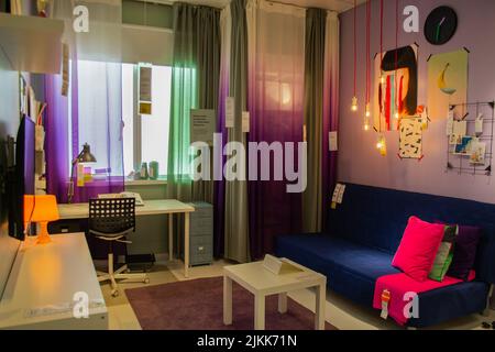 Mosca, Russia, Settembre 2019: IKEA Store Interiors: Camera luminosa per un adolescente, in colori scuri, con accessori colorati: divano, poster sulla parete Foto Stock