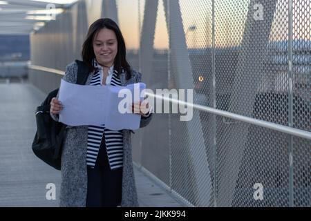 ritratto di una ingegnere donna che indossa uno zaino guardando piani ponte Foto Stock