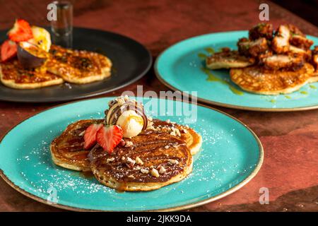 Un primo piano di deliziosi pancake con gelato e fragole Foto Stock
