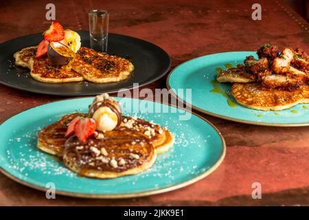 Un primo piano di deliziosi pancake con gelato e fragole Foto Stock