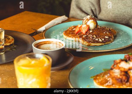 Un primo piano di deliziosi pancake con caffè e succo di frutta Foto Stock