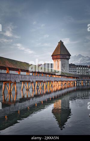 Una panoramica del ponte di Lucerna durante la serata circondato dal lago e dal paesaggio urbano Foto Stock