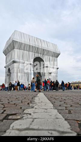 Uno scatto verticale dell'Arco di Trionfo con una folla, avvolto in tessuto blu argenteo e corda rossa Foto Stock