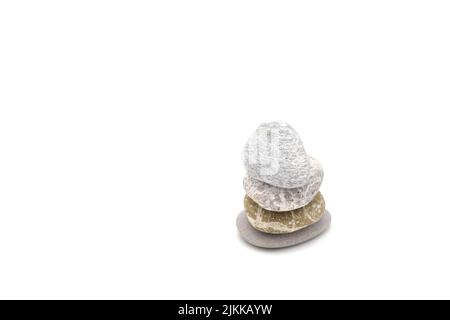 Una carta da parati con quattro piccole rocce l'una sopra l'altra isolata su sfondo bianco Foto Stock