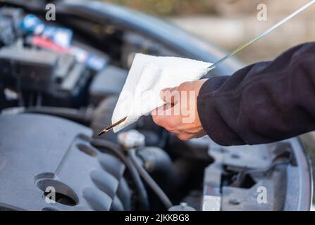 Man sta controllando il livello dell'olio sulla vettura Foto Stock