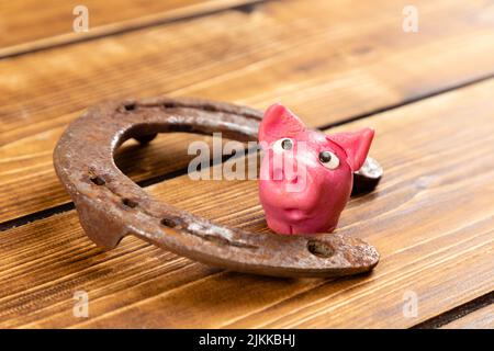 horseshoe con segno di maialino fortunato per fortuna per la giornata di san patricks su uno sfondo di legno Foto Stock
