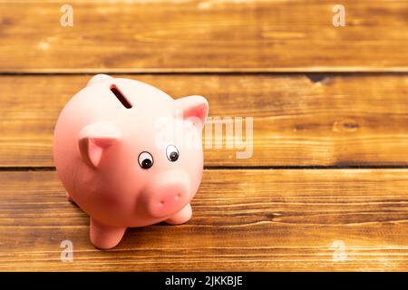 pink piggy bank su sfondo di legno Foto Stock