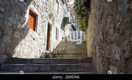 Un colpo di scale di pietra che saliscono fino a un cortile contro vecchie case a Dubrovnik, Croazia Foto Stock