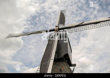 Inquadratura ad angolo basso di un mulino a vento olandese sotto un cielo nuvoloso Foto Stock