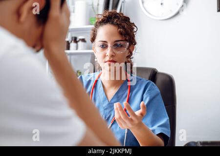 Medico femminile che fa un esame di consultazione con una triste pazienza. Foto Stock
