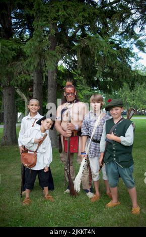 Dei bambini e un guerriero irochese vestito con abiti d'epoca. Old Fort Niagara state Park, New York Foto Stock