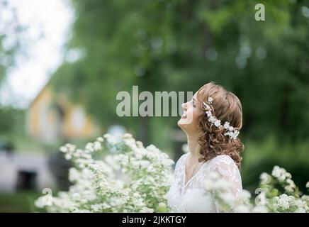 Una foto selettiva di una bella sposa con un bouquet di fiori in giardino Foto Stock