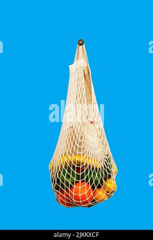 Borsa bianca con diversi tipi di verdure e frutta su sfondo blu. Vista dall'alto Foto Stock