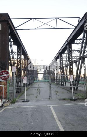 Uno scatto verticale di un vecchio, inutilizzabile, ponte di metallo con segnali di avvertimento Foto Stock