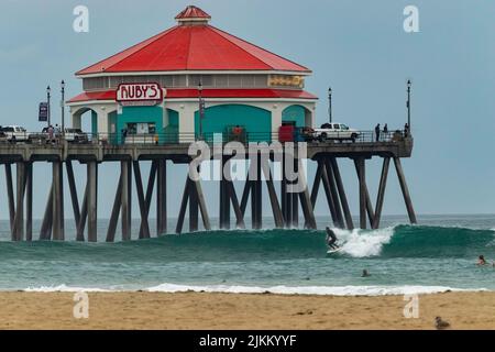 Una vista panoramica di un ristorante Ruby's su un molo sopra le persone che navigano a Huntington Beach, California Foto Stock