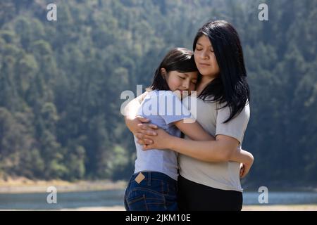 Madre e figlia messicana che abbraccia all'aperto, giornata delle donne Foto Stock