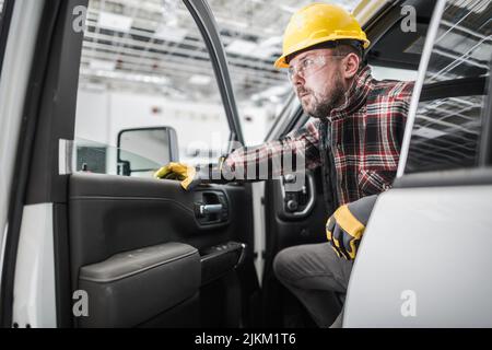 Il lavoratore dei cantieri caucasici è arrivato al cantiere. Uscita dal suo camion di raccolta. Tema dell'industria delle costruzioni. Foto Stock