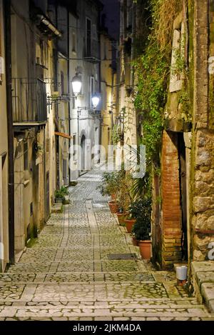 Uno scatto verticale di una strada stretta tra vecchi edifici in un villaggio in provincia di Benevento in Italia. Foto Stock