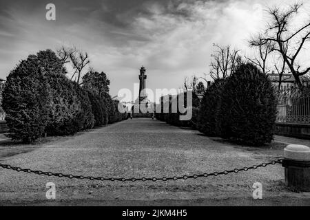 Un'immagine in scala di grigi di un modo per raggiungere il monumento con una croce e sculture durante il giorno. Foto Stock