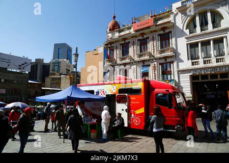 La Paz, Bolivia. 2nd agosto 2022. Un medico chats con un paziente vicino ad una clinica mobile di salute che offre la salute libera e controlli dentali / consultazioni. Il servizio è organizzato dalle autorità della città di la Paz in Plaza San Francisco nel centro della città. SEMA165 (sul lato del camion) è il Servizio comunale di ambulanza (Servicio Municipal de Ambulancias) Foto Stock