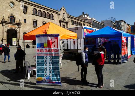 La Paz, Bolivia. 2nd agosto 2022. Una clinica medica temporanea che offre informazioni e consulenze gratuite in modo che le persone possano controllare se hanno il diabete. Il banner ha un elenco di possibili sintomi in spagnolo in modo che la gente possa decidere quanto è probabile che siano di avere il diabete. Dietro fa parte della chiesa e del convento di San Francisco, la chiesa coloniale più importante e suggestiva della città. Foto Stock