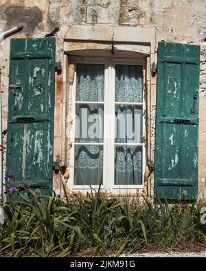 Uno scatto verticale delle finestre di una vecchia casa distrutta Foto Stock