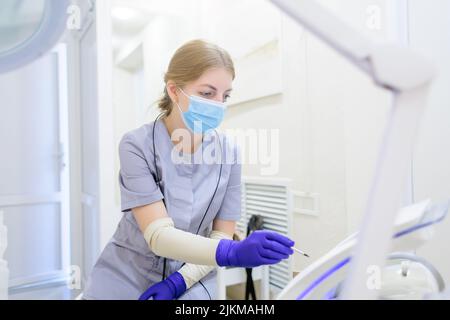 Il master per l'elettroepilazione si trova sul posto di lavoro e configura il dispositivo per l'elettroepilazione Foto Stock