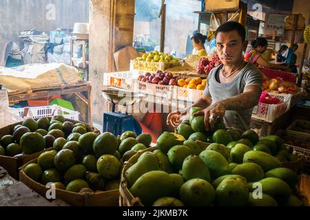 Uomo balinese che vende frutta al mercato mattutino di Ubud, Bali, Indonesia Foto Stock