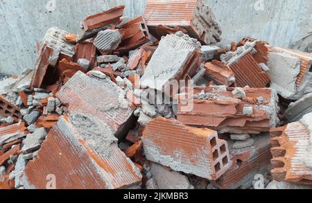 Un mucchio di mattoni rotti contro un muro Foto Stock